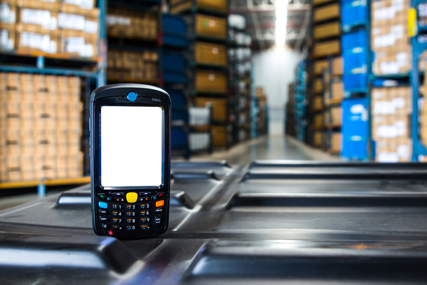 Bluetooth barcode scanner in front of modern warehouse / © photoraidz / Fotolia.com.